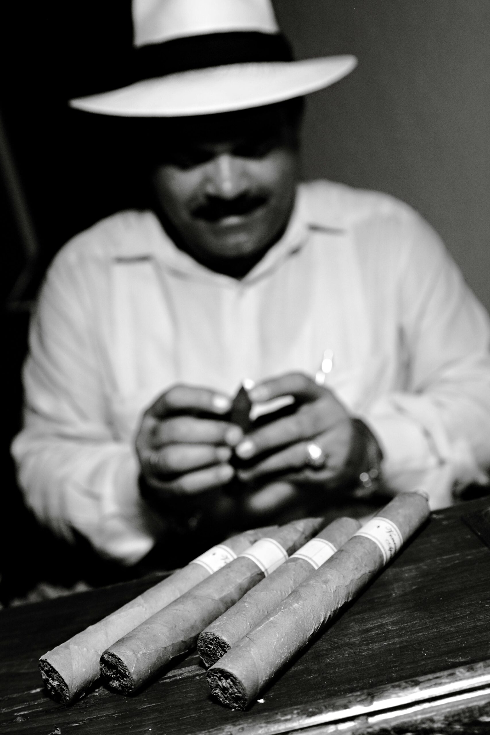 A skilled craftsman meticulously rolling cigars in Cuba, showcasing traditional cigar-making techniques.