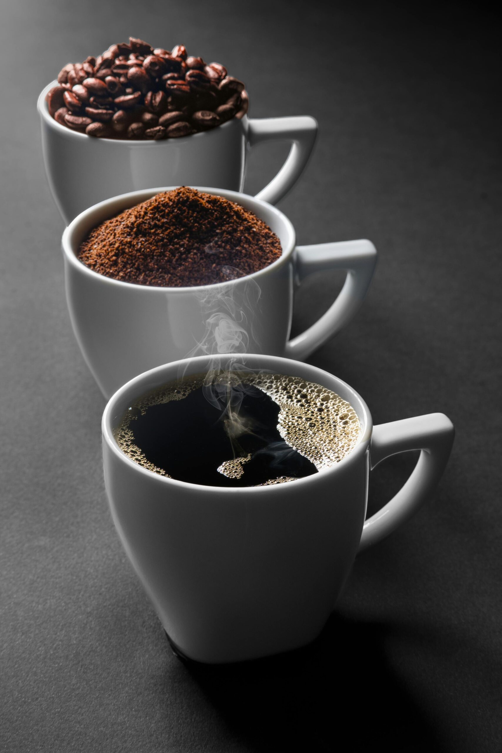 A journey of coffee from beans to a fresh brew in three cups, highlighting the stages of preparation.
